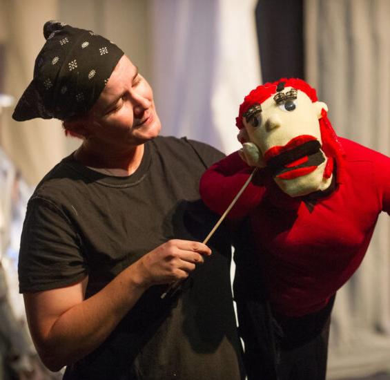Theatre student performing with a puppet.