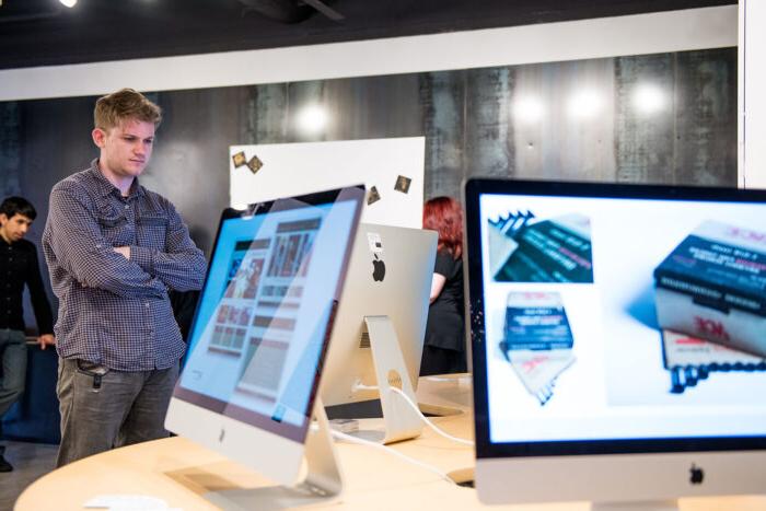 在画廊里展示数字媒体的Mac电脑.