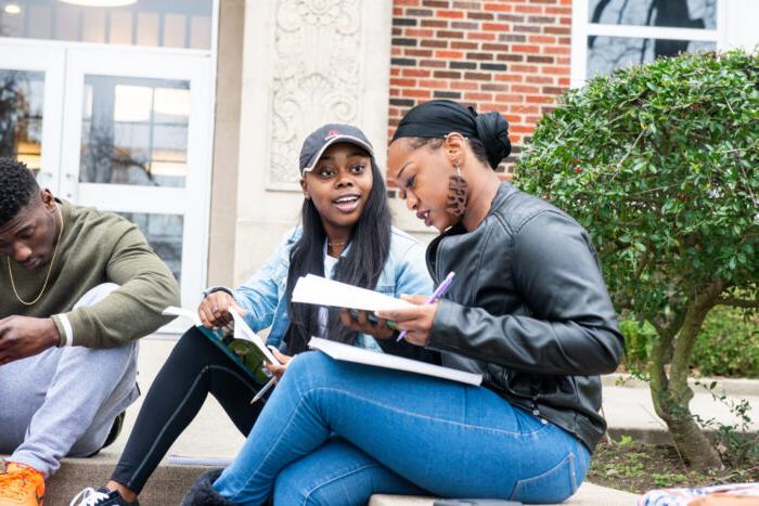 Students studying on the steps outside.