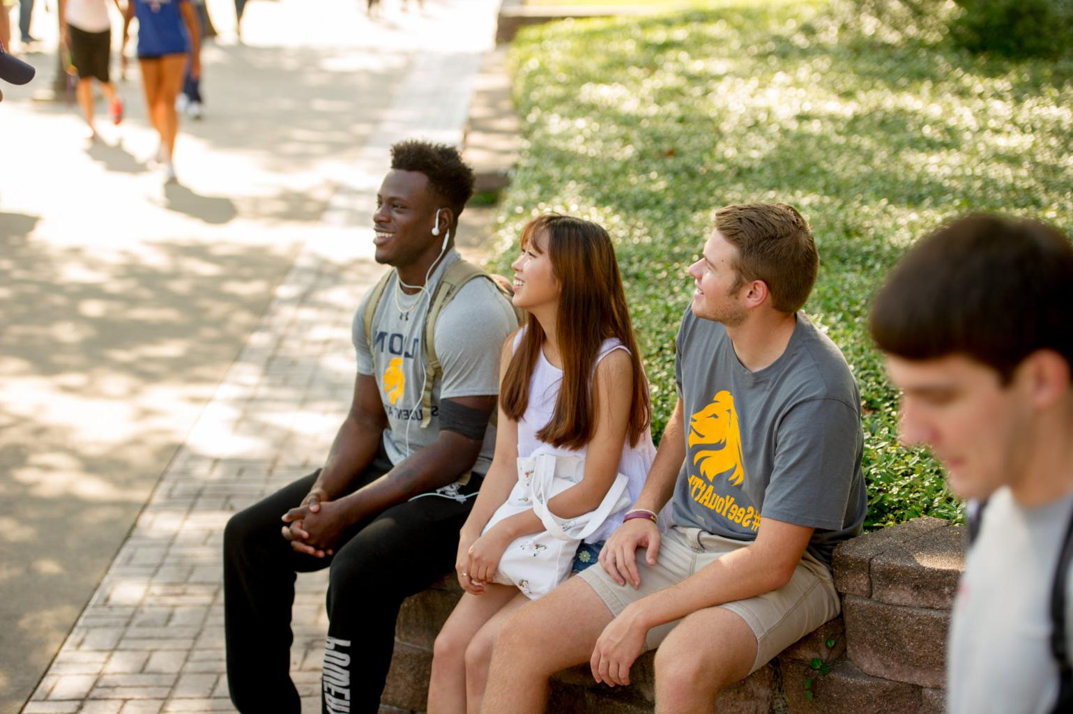 Group of students sitting on campus.