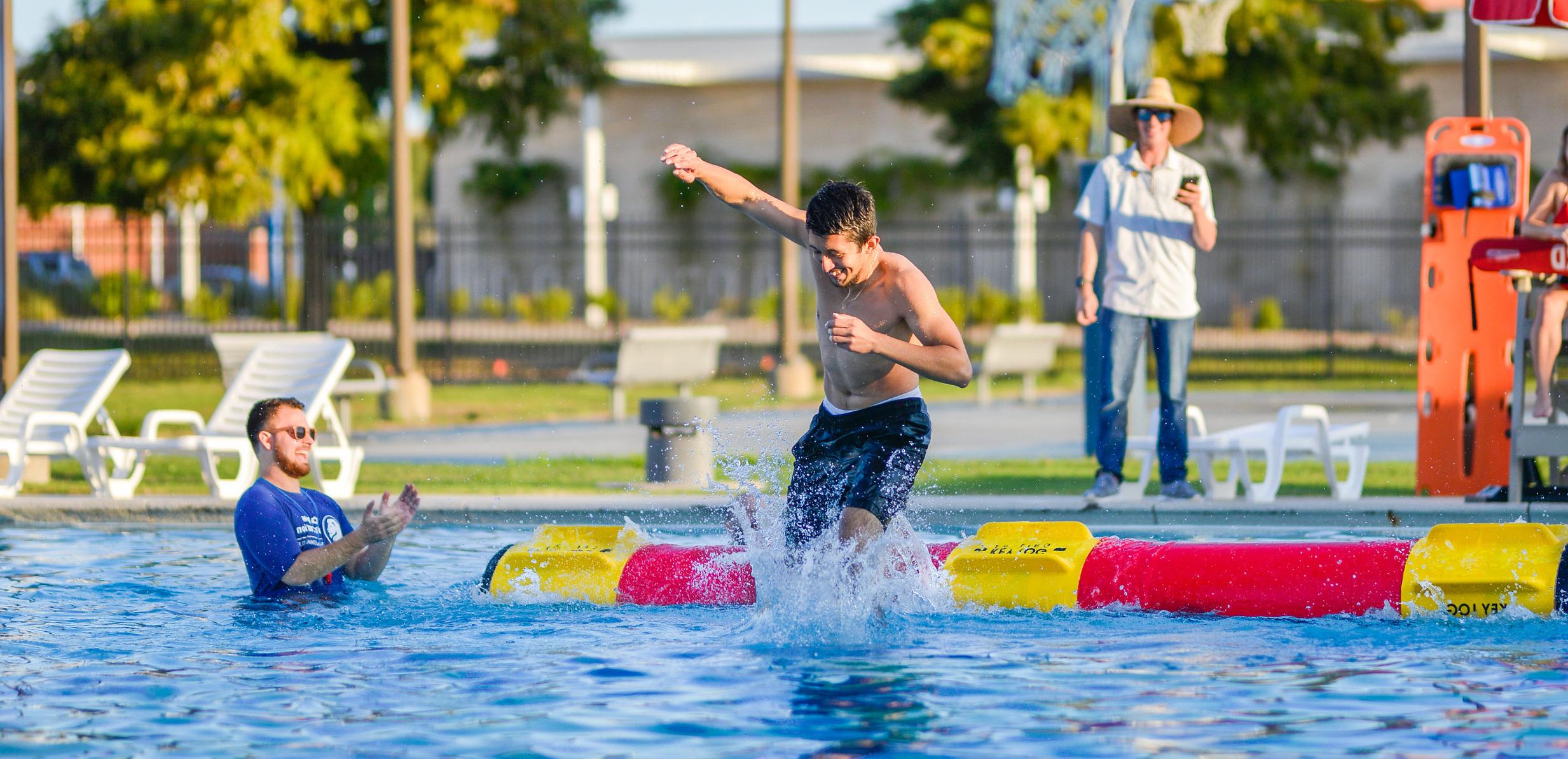 A student during a log rolling competition at the Campus Recreation pool. 