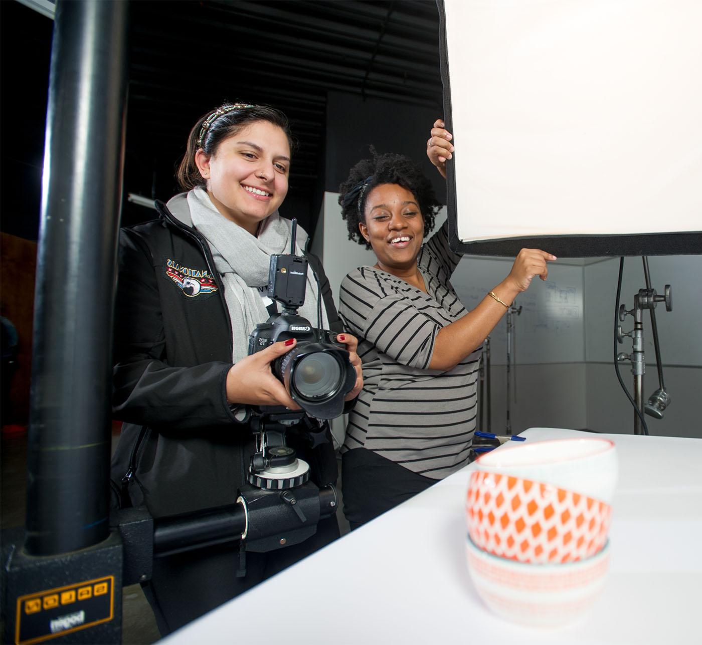 Two female students working together on a photography project.